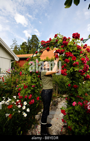 Una donna giapponese nel suo giardino svedese in Svezia. Foto Stock