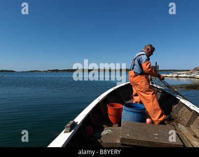 Un uomo di pesca in barca in Svezia. Foto Stock