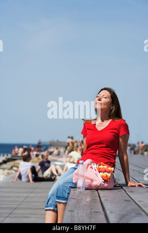 Una donna godendo il sole Skane Svezia. Foto Stock