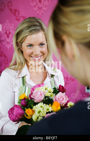 Una donna bionda che lavora in un negozio di fiori in Svezia. Foto Stock