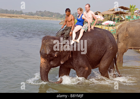 Elephant di balneazione con i turisti in Rapti Rapoti fiume nel Parco nazionale di Royal Chitwan Nepal Foto Stock