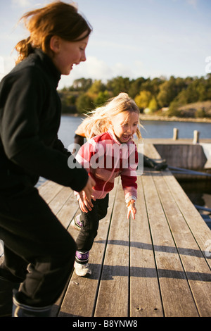 Due ragazze giocando su un pontile arcipelago di Stoccolma in Svezia. Foto Stock