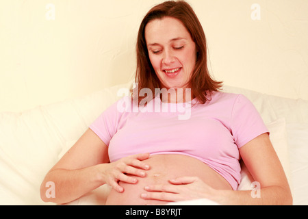 Sano giovane blooming risplendente donna incinta gode il suo terzo trimestre di gravidanza in un momento di relax a casa in buona salute Foto Stock
