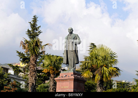 Una statua in bronzo del rivoluzionario russo Lenin si erge tra alberi di palma in piazza a Yalta, Crimea, Ucraina. Foto Stock