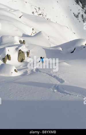 Sci con rifiniture in giù una meravigliosa collina con rocce in fresco di neve caduti Foto Stock