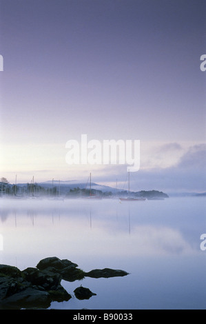 Vista nebbiosa all'alba di barche on Windermere, visto dal punto di Cockshott, Cumbria Foto Stock