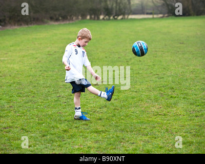 Giovane ragazzo giocando a calcio calcio su un passo Foto Stock