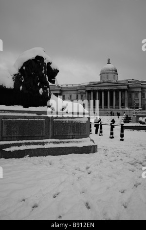 La neve sul Landseer Lions e National Gallery in Trafalgar Square, Londra Foto Stock