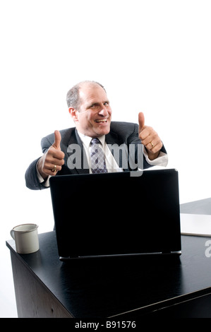 Entusiasta il senior management esecutivo al desk con positivo segno di successo pollice in alto Foto Stock