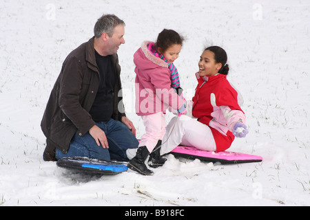 Padre bianco figlia toddlerl etnica nero razza mista sorridenti divertirsi giocando a snow ice giovani Foto Stock