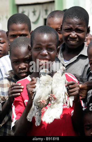 Nigeria: boy con due piccioni bianco Foto Stock