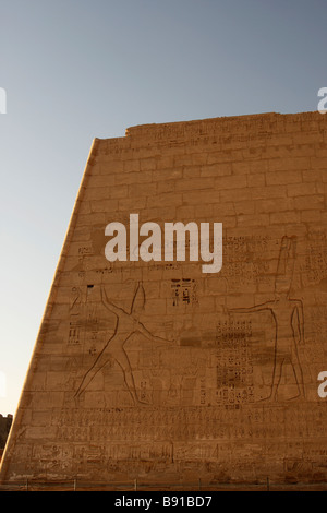 Il sollievo di Ramses III uccidendo nemici e il dio Amon scolpito sul primo pilone di [Medinet Habu] Tempio, 'West Bank", Luxor, Egitto Foto Stock