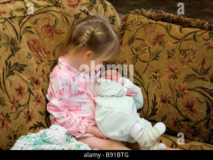 Una bambina tenendo il suo bambino sorella per la prima volta Foto Stock