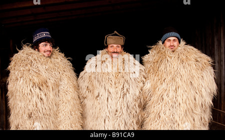 Il rumeno pastori in abbigliamento tradizionale tra una grande sheeps pesante vello Foto Stock