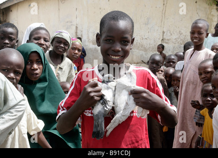 Nigeria: boy con due piccioni bianco Foto Stock