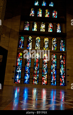 La chiesa superiore le finestre di vetro macchiate riflesso sul pavimento a mosaico all'interno della Basilica dell'Annunciazione di Nazareth Israele Foto Stock