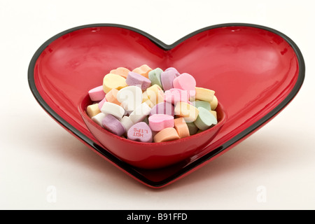 Piccolo piatto candy riempito con a forma di cuore ad candy all'interno di un più grande a forma di cuore piatto di caramelle Foto Stock