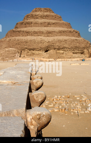 [Passo piramide] e fregio scolpito in pietra cobra capi sulla tomba del Sud Cappella, complesso funerario di Djoser, Saqqara, Egitto Foto Stock