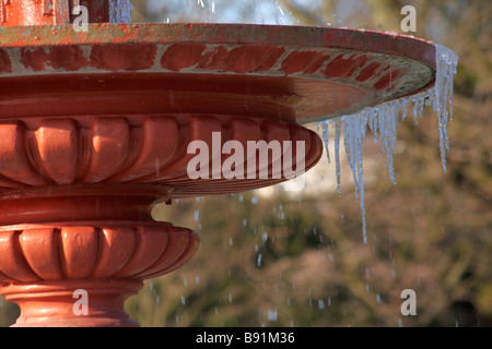 Ghiaccioli appesi da Fontana nel parco di Poole, Dorset nel gennaio Foto Stock