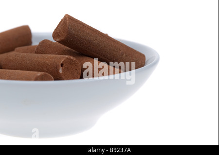 Caramelle alla cannella bastoni in un recipiente isolato su uno sfondo bianco Foto Stock