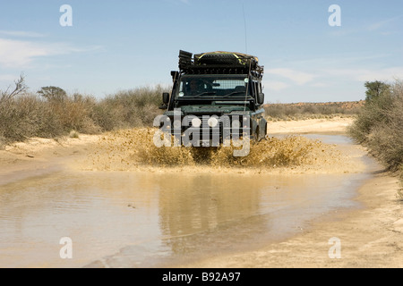 4x4 la guida attraverso acqua Kgalagadi Trans Parco di frontiera Sud Africa Foto Stock