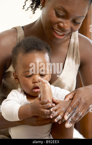 Madre mettendo la crema sul suo bambino s piedi Cape Town Western Cape Province Sud Africa Foto Stock