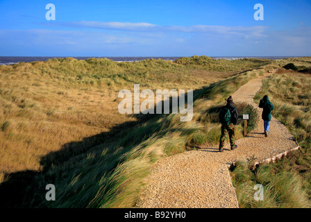 Walkers a Holme dune di sabbia Riserva Naturale Nazionale Holme accanto al mare Costa North Norfolk England Regno Unito Foto Stock