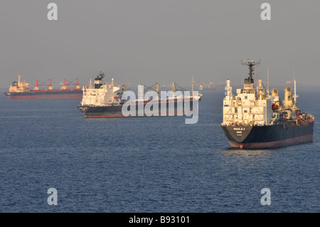 Le navi senza carico, le navi portarinfuse e le petroliere hanno gettato l'ancora dal porto di rifornimento di petrolio di Fujairah, Golfo dell'Oman, vicino allo stretto di Hormuz, una foschia calda lontana Foto Stock