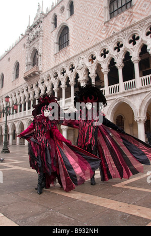 Il Carnevale di Venezia. 2 caratteri rosa Red Hat Costume e Maschera piume San Marco. Venezia Veneto Italia Europa 91685verticale Venezia Foto Stock
