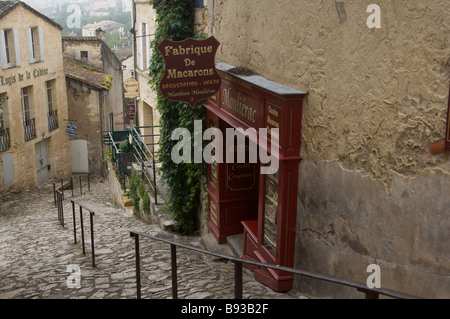 La strada di ciottoli in St Emilion Bordeaux Francia con un Amaretto shop Foto Stock
