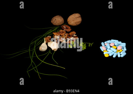 Ingredienti sani e pillole su sfondo nero Foto Stock