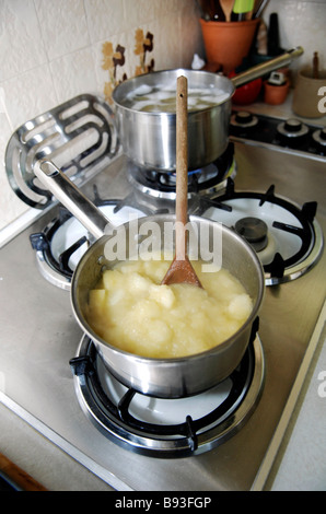 Una pentola contenente la salsa di apple viene riscaldata su un piano di cottura per cucina Foto Stock