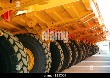 Vista posteriore o inferiore del articolato caterpillar autostrada camion ordinatamente parcheggiate nel pattern ripetitivo Foto Stock
