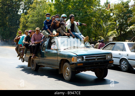 Gli uomini e le motociclette pack su un carrello a cavallo lungo la strada che da Phnom Penh di Kompong Chhang Foto Stock