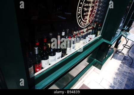 Una vetrina con bottiglie di vino sul davanzale della finestra Foto Stock