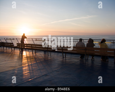 Le persone che si godono il tramonto dalla parte posteriore della piattaforma di visualizzazione di Oscar Wilde traghetto per auto Foto Stock