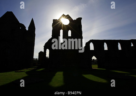 Il sole splende attraverso il rosone del famoso e storicamente importanti resti di Arbroath Abbey in Scozia, Regno Unito Foto Stock