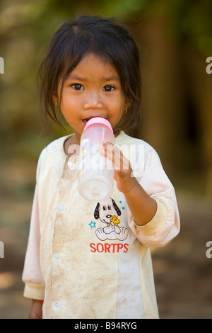 I giovani cambogiani ragazza con una bottiglia fotografata in corrispondenza di un'isola villaggio sul fiume Mekong Phnom Penh Cambogia Foto Stock