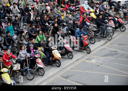 Folla su biciclette e motociclette attraversando in Shanghai Foto Stock