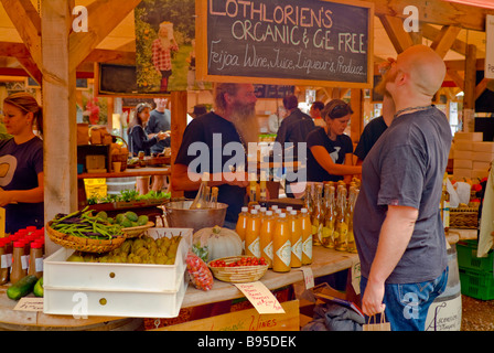 Un cliente dei campioni dei vini di frutta al Mataka agricoltore frutta Marker del vino liquoroso e produrre stand. Foto Stock