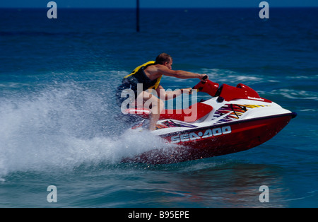 SPORT Sport Acquatici getto sci uomo a cavallo di un jet ski sul mare a Littlehampton in West Sussex England. Visto dal lato. Foto Stock