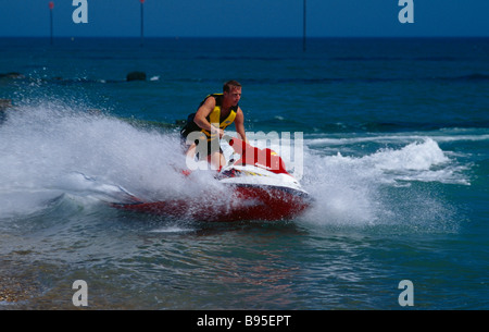 SPORT Sport Acquatici getto sci uomo a cavallo di un jet ski sul mare a Littlehampton in West Sussex England. Foto Stock