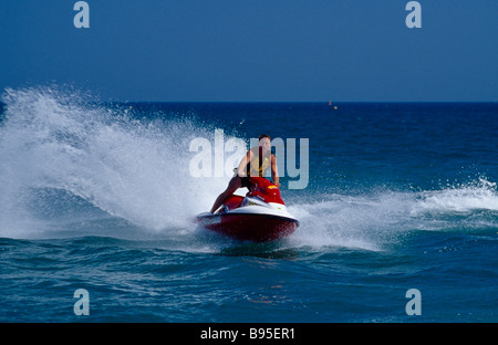 SPORT Sport Acquatici getto sci uomo a cavallo di un jet ski sul mare a Littlehampton in West Sussex England. Osservato dalla parte anteriore. Foto Stock