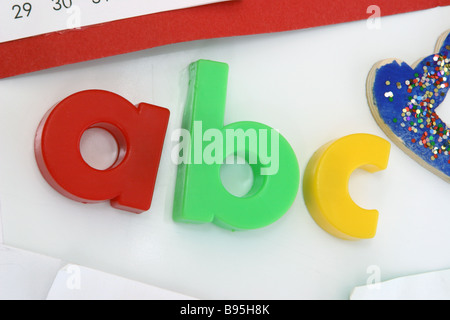 Magnetico colorato ABC lettere su una bianca porta di frigorifero Foto Stock