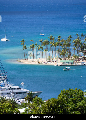 WEST INDIES Caraibi St Lucia Castries Marigot Bay Yacht al di ancoraggio al di là di piccole palme da cocco alberata di spiaggia Beach Club Foto Stock