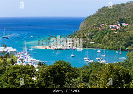 WEST INDIES Caraibi St Lucia Castries Marigot Bay Yacht al di ancoraggio al di là di piccole palme da cocco alberata di spiaggia Beach Club Foto Stock