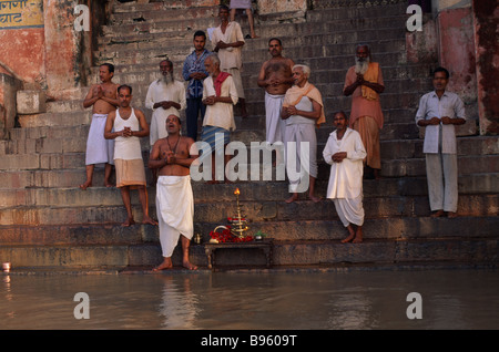 INDIA Asia Meridionale Uttar Pradesh Varanasi gruppo di uomini indù culto sui passi al fiume Gange. Foto Stock