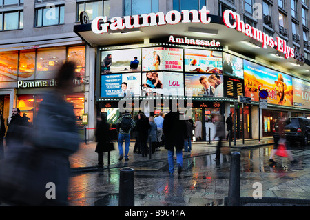 Parigi Champs Elysees occupato, Francia, Busy Street Scene Cinema Theatre, illuminato, pioggia, crepuscolo Cinema Teatro poster Marquee, in attesa fuori francese Foto Stock