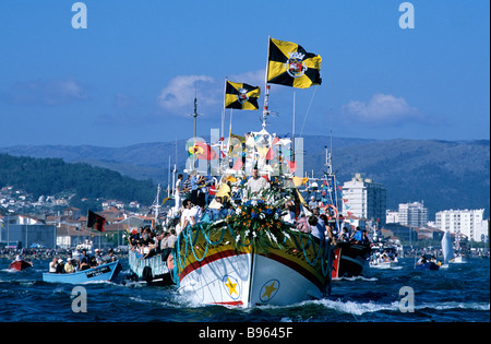 Un peschereccio che partecipano nella colorata Romaria de Nossa Senhora d'Agonia festeggiamenti a Viana do Castelo, Portogallo Foto Stock