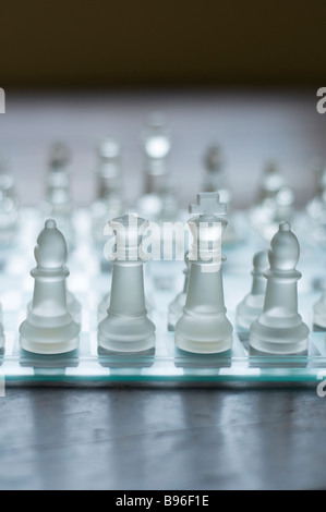 Il livello degli occhi vista di vetro set di scacchi su un pavimento di legno Foto Stock